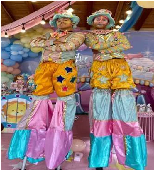 Dos zanqueros con trajes en tonos pastel